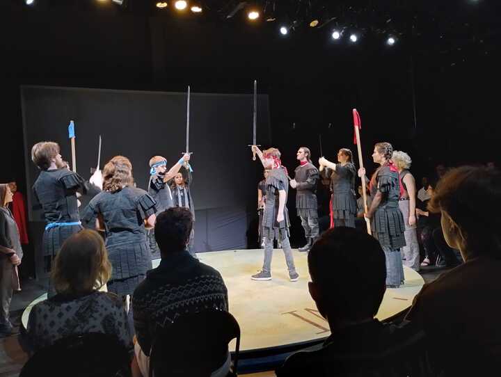 Student actors holding swords prepare to battle onstage in Pellissippi State's production of Antigone.