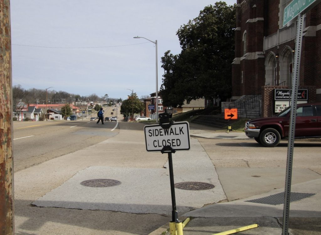 Sidewalk closed on Magnolia Avenue. Picture shows a sign and a streetscape.