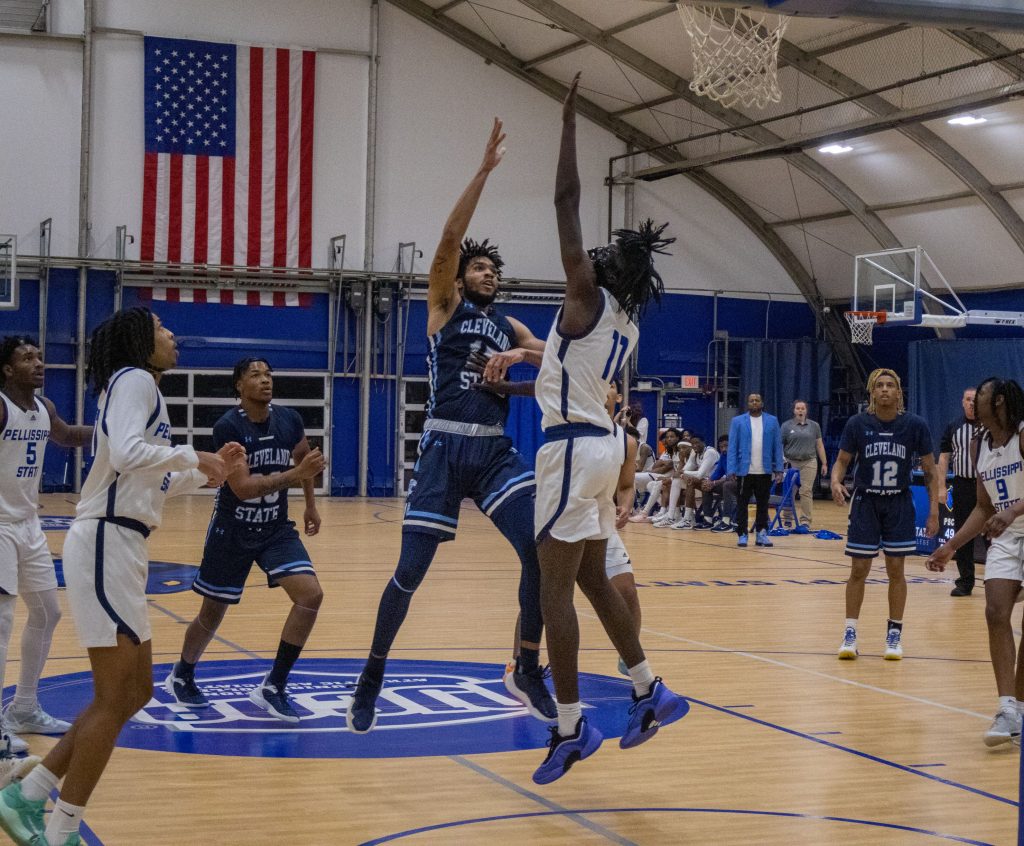 Two basketball players skirmish at the basketball hoop.